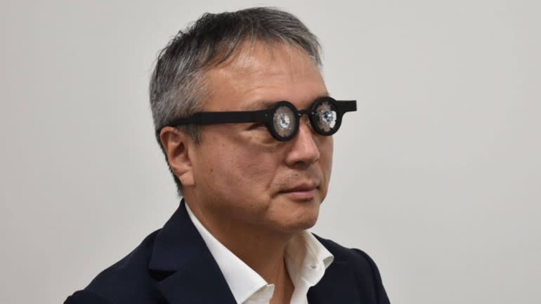 Ryo Kubota, president of Kubota Pharmaceutical, tries out his company's wearable device for the treatment of nearsightedness. (Photo courtesy of the company)